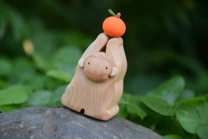 申年をモチーフにした木工クラフト(タンカンを手にしている)