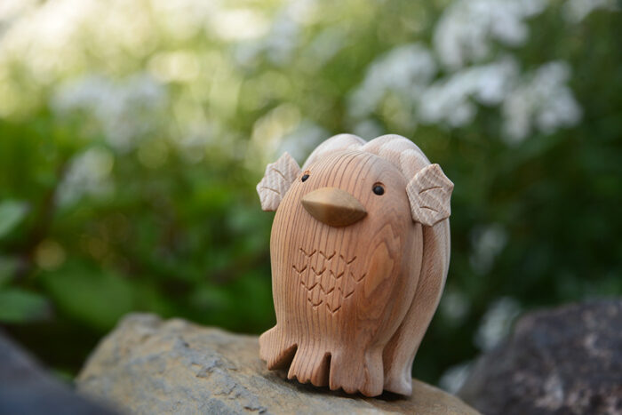 白い花をバックに立つアマビエのクラフト